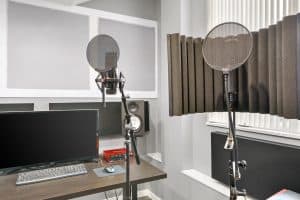 Music production studio with Yamaha studio monitors, microphones, and midi keyboard.