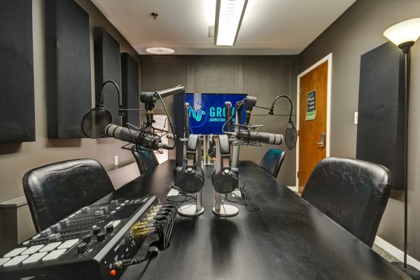 Podcast studio with Microphones, Headphones, TV, and chairs